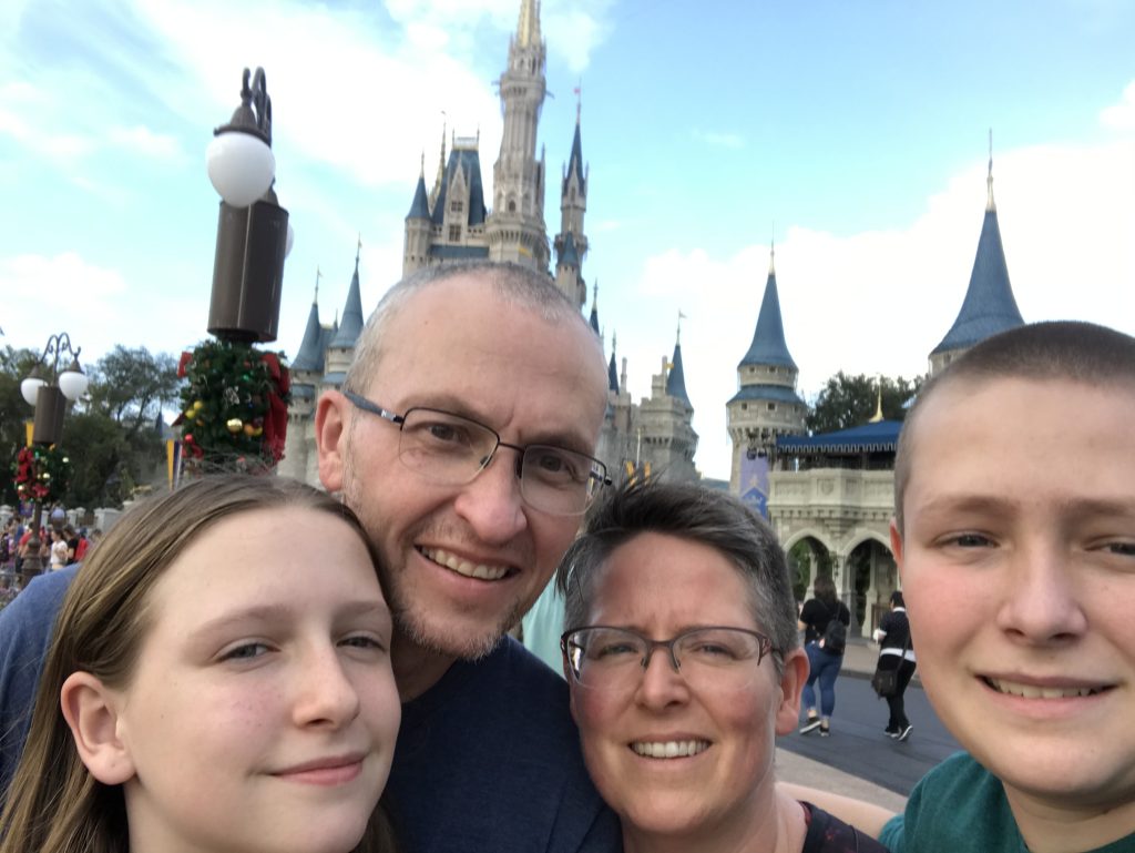 A family in front of the Disney castle.