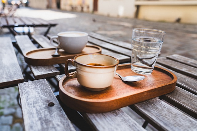 Coffee on slatted table on cobblestone street
