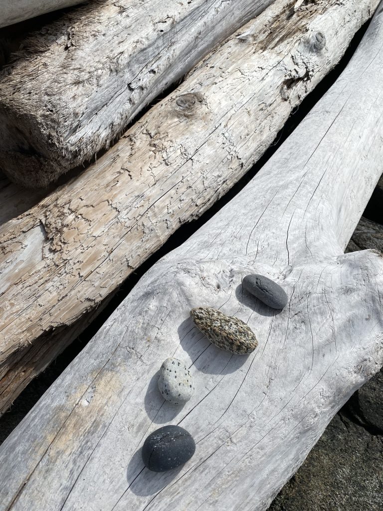 Four stones on driftwood.