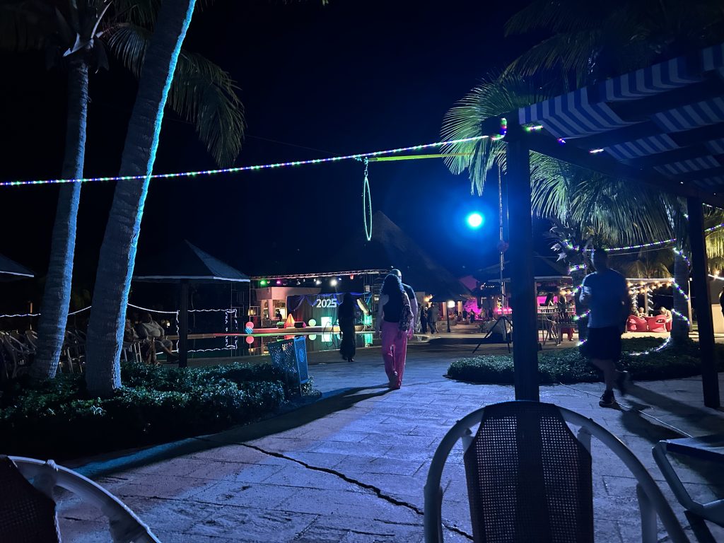 Resort poolside lit up by colourful lights.