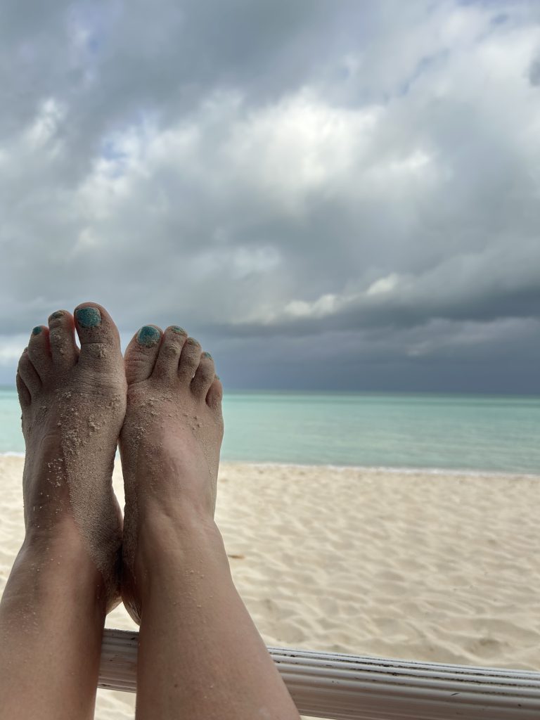 feet on railing near beach