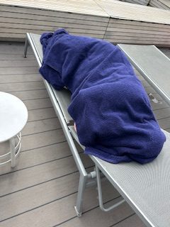 Woman wrapped in towels on a deck chair