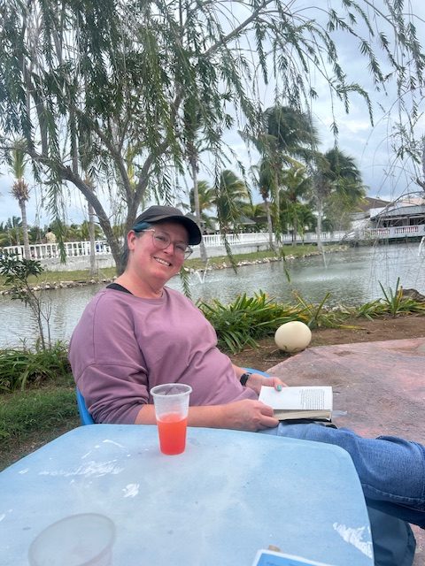 woman beside water reading