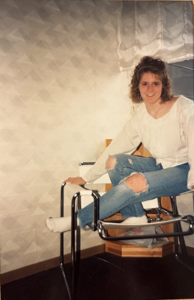 Girl on chair in ripped jeans