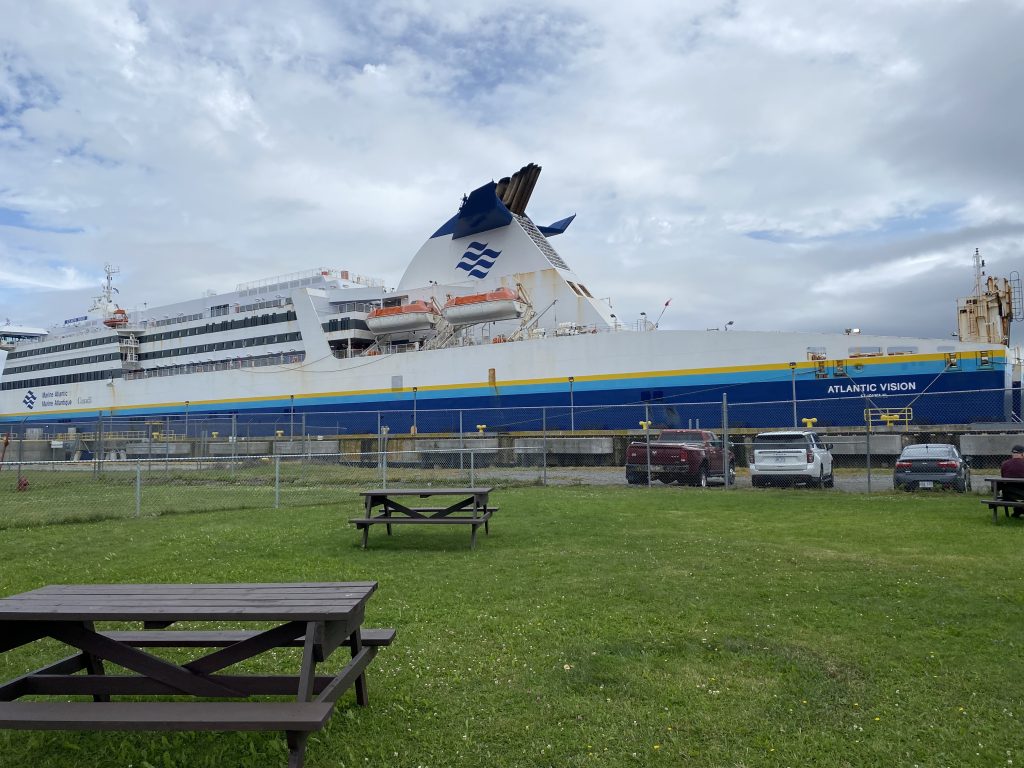 ferry docked with grass and park in front