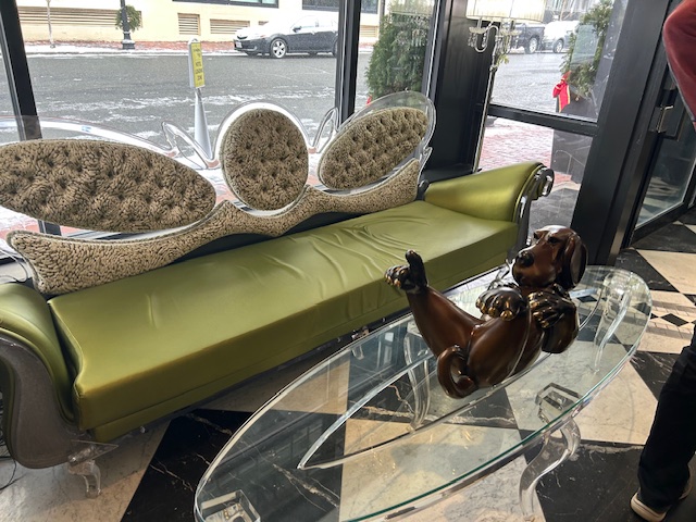 green funky couch and dog statue