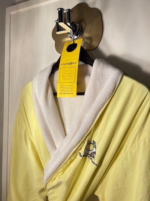yellow bathrobe hanging on hook
