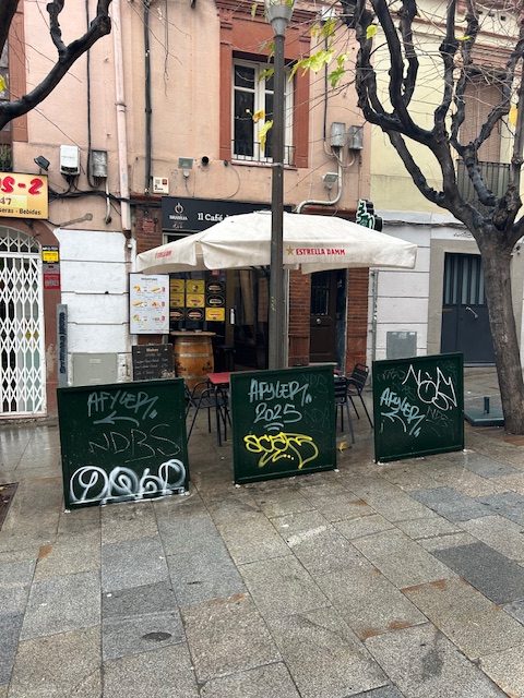 graffiti on cafe fence barriers in Barcelona Spain