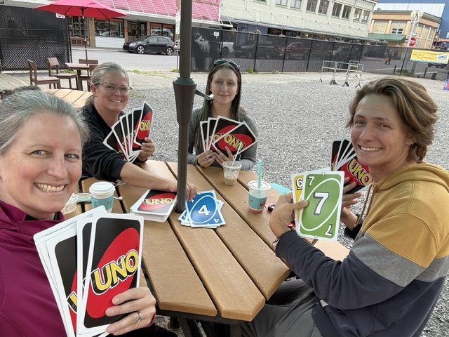 four people playing UNO with giant cards