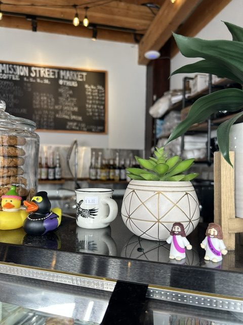 two mini Jesus statues above cafe baked goods