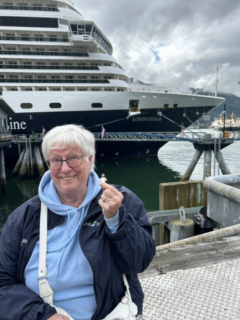 woman with Jesus statue in front of cruise ship